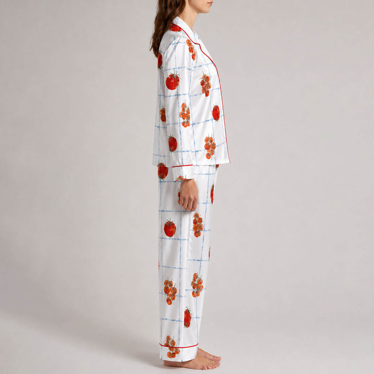 Side view of women’s satin pajamas with red fruit and branch graphics