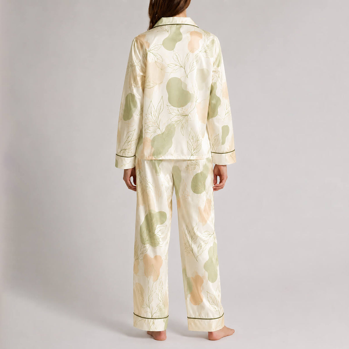 Back view of cream satin pajamas with soft green botanical pattern